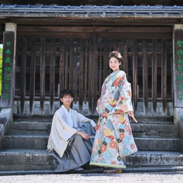 お寺の階段に座る新郎新婦