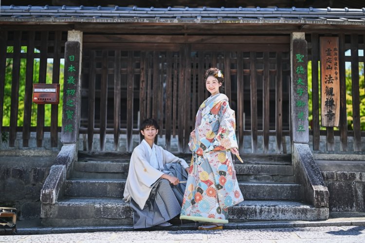 お寺の階段に座る新郎新婦