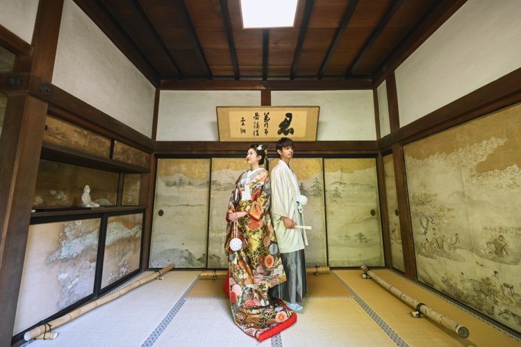 和室の真ん中に立っている新郎新婦