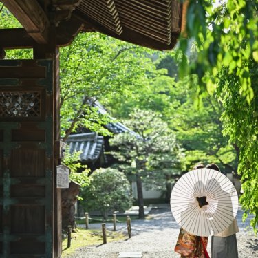 白色の和傘を持っている新郎新婦