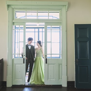 かわいい扉の前で、新しい門出を祝う結婚写真を