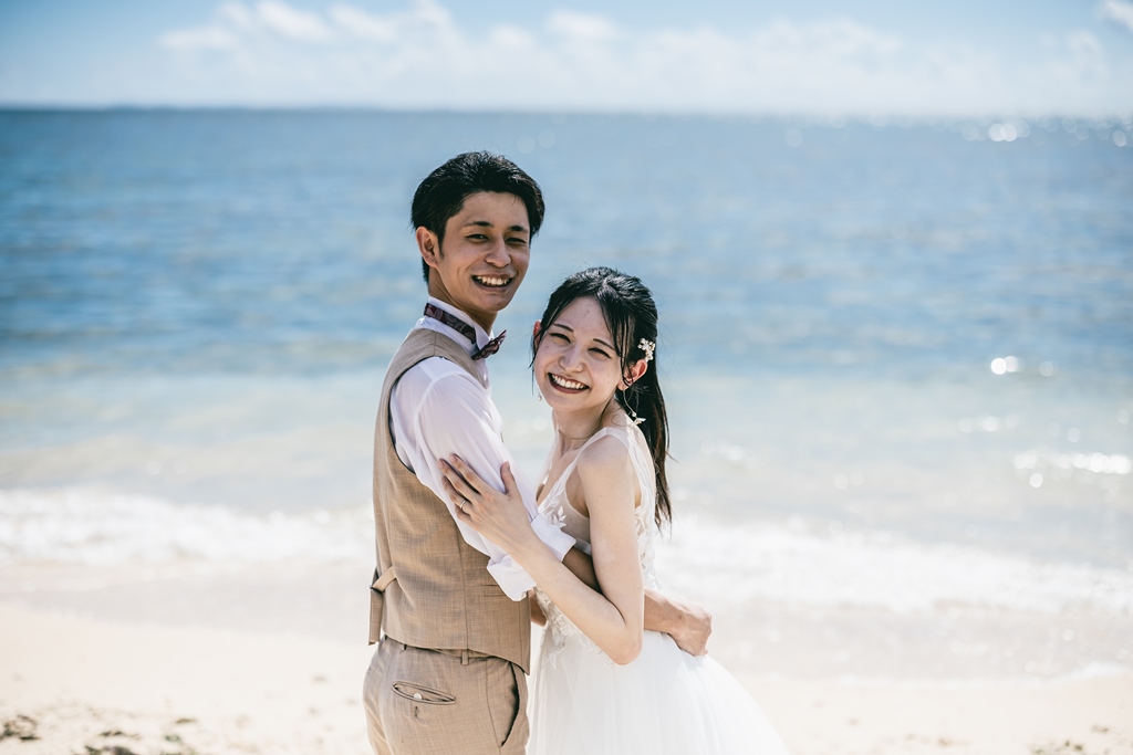 沖縄の海をバックに笑顔のふたり