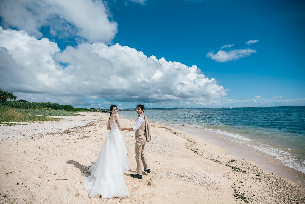 沖縄の海を手を繋いで歩くふたり