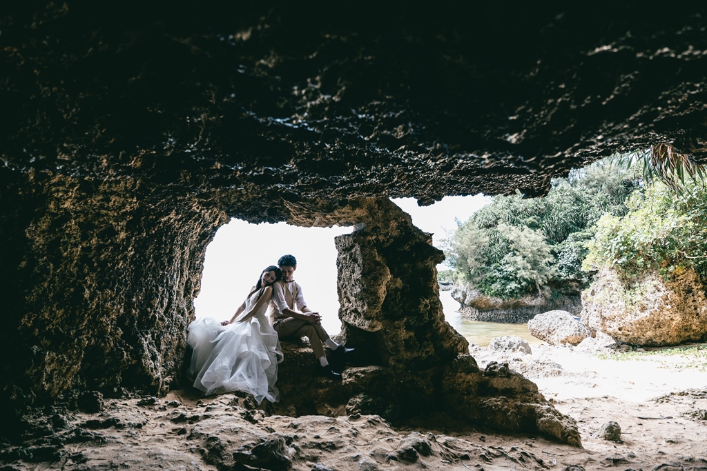 ザネー浜の人気スポットで肩を寄せ合う新郎新婦の写真