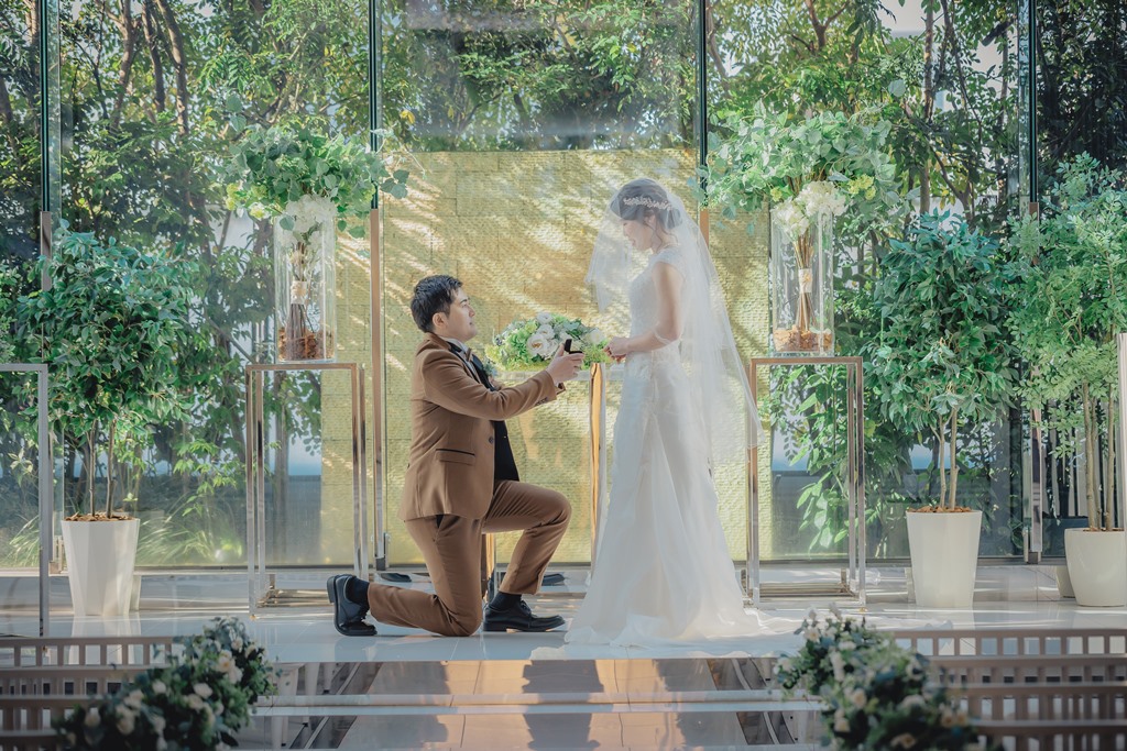 青空の見える解放的なチャペルでお互いに手を取り合って