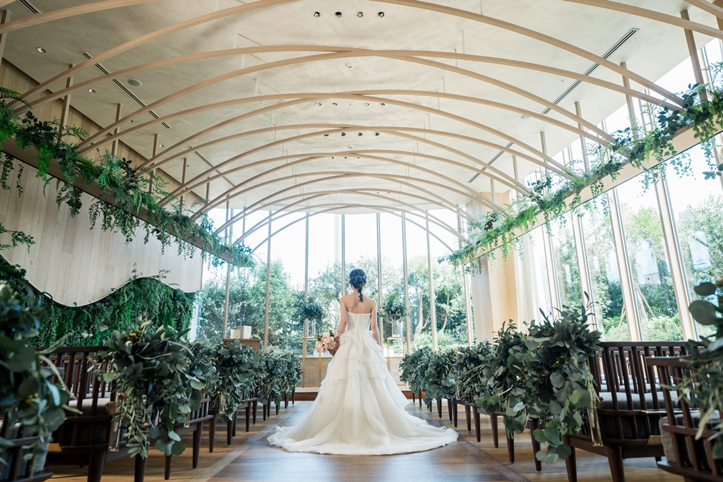 景色の良いチャペルのベンチに座っている新郎新婦