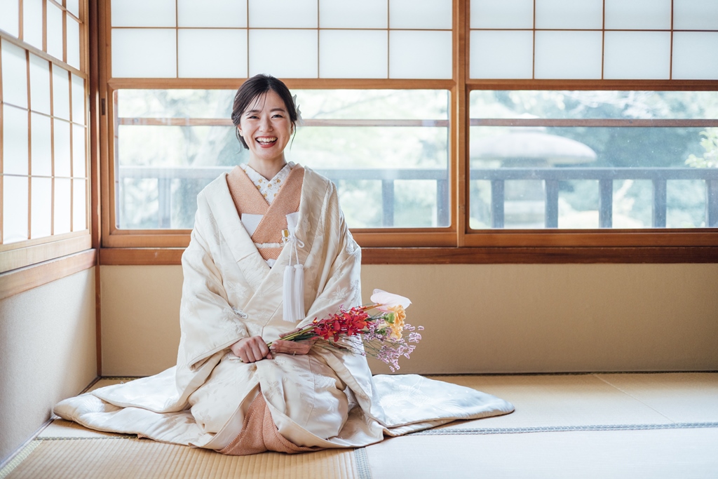 和室で正座をしている笑顔の新婦