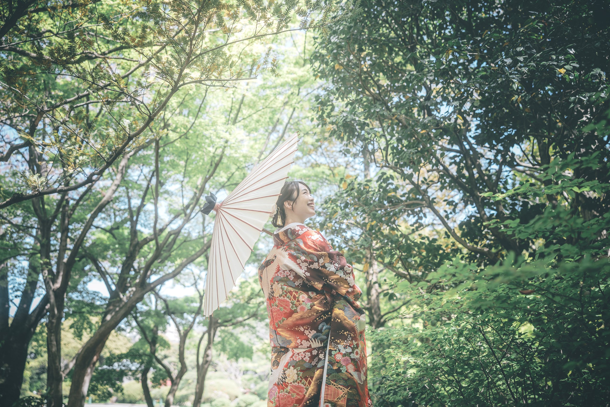 色打掛を着て白い和傘を差している花嫁