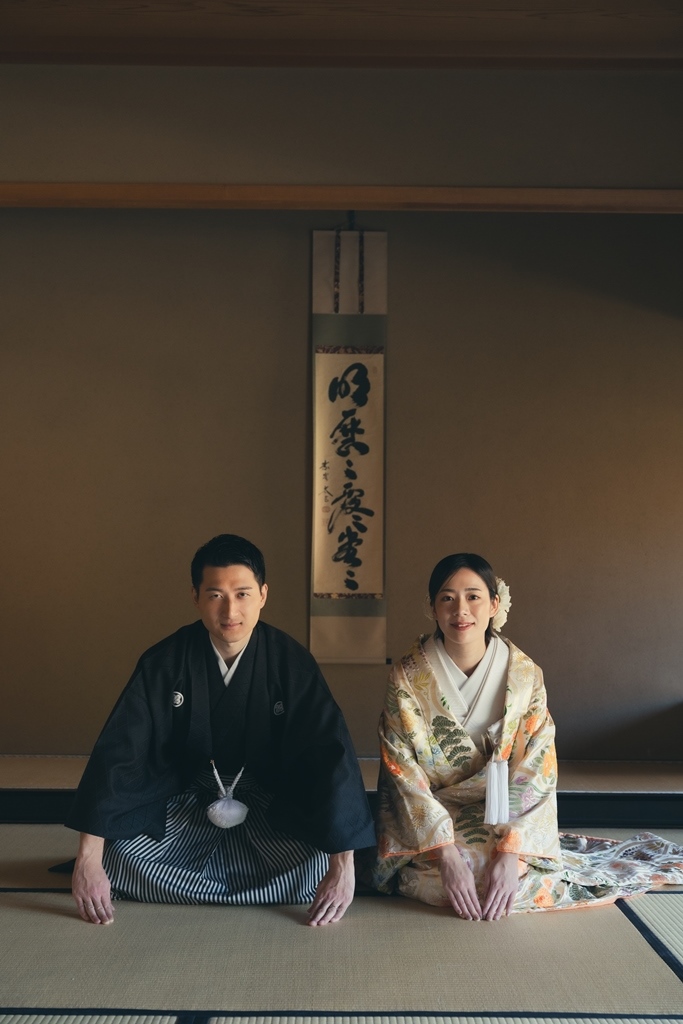 オシャレな着物を着て正座をしている夫婦の写真