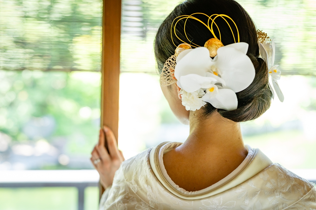 生花を飾った洋髪シニヨンアップスタイルの白無垢花嫁の美しいショット