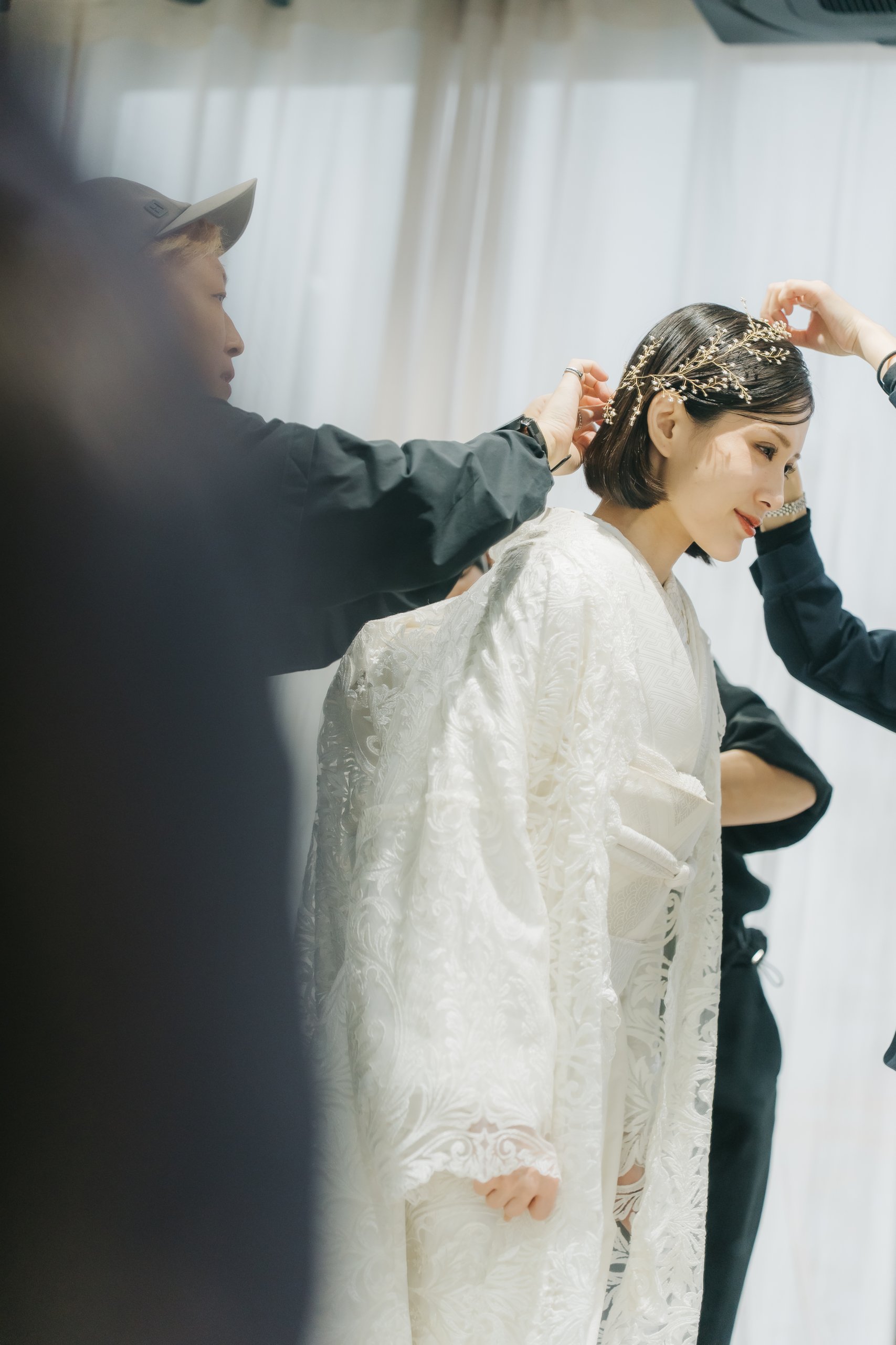 表参道店のヘアメイクアーティストが白無垢花嫁のヘアを丁寧に仕上げているシーン