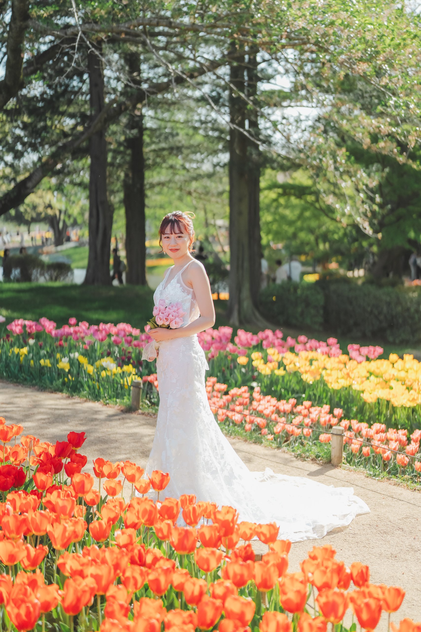 昭和記念公園の花の丘でのウェディングドレス前撮り、一面に広がる花畑の中で純白のウェディングドレスが圧倒的な存在感で際立つ美しい一枚