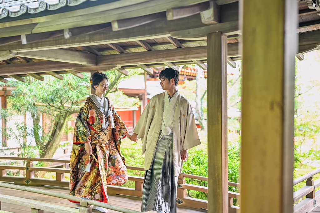 毘沙門堂の渡り廊下を手をつないで歩く夫婦