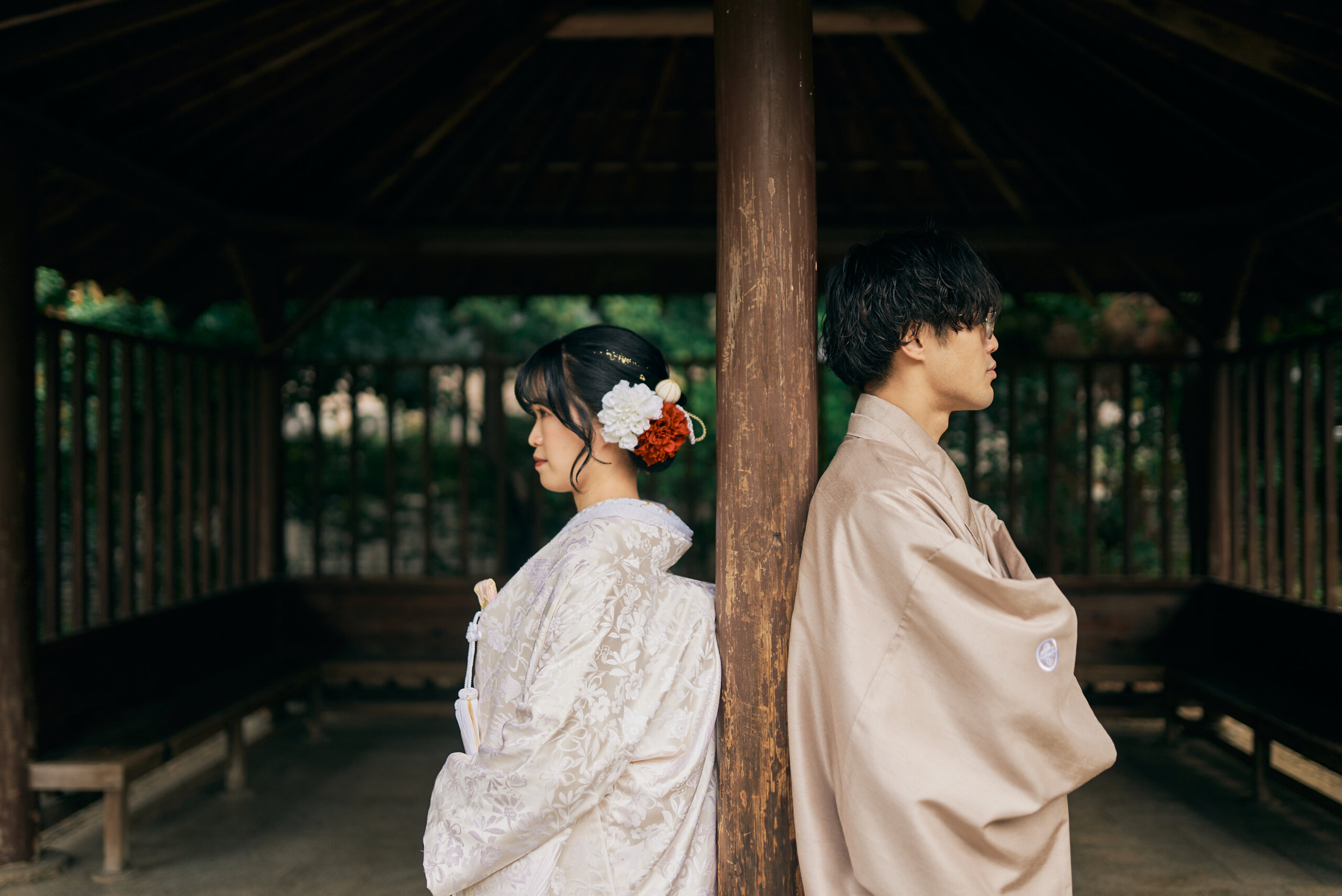甘泉園公園の木々を背景に白無垢の繊細な織り柄が浮かび上がる新婦のアップ写真