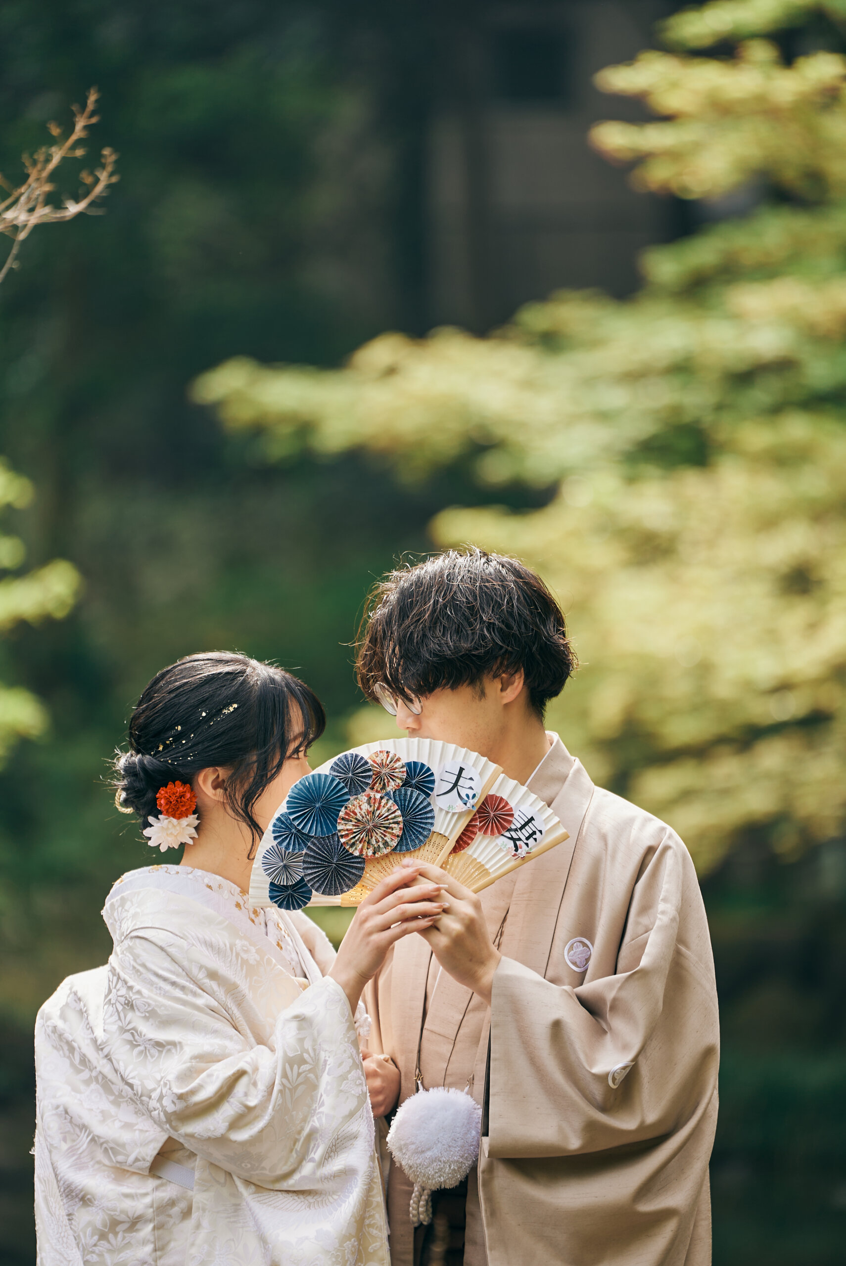 甘泉園公園の庭園で生花の髪飾りをつけた洋髪スタイルの和装の新婦の横顔の写真