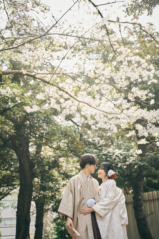 甘泉園公園の色づいた紅葉を背景に金と赤の色打掛を着た新婦の写真