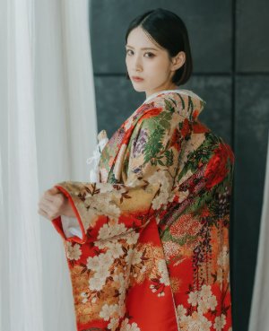 赤地に金の花々が咲く王道の色打掛を肩にまとって振り返る、表参道店の和装前撮りの花嫁（衣装番号DR02）
