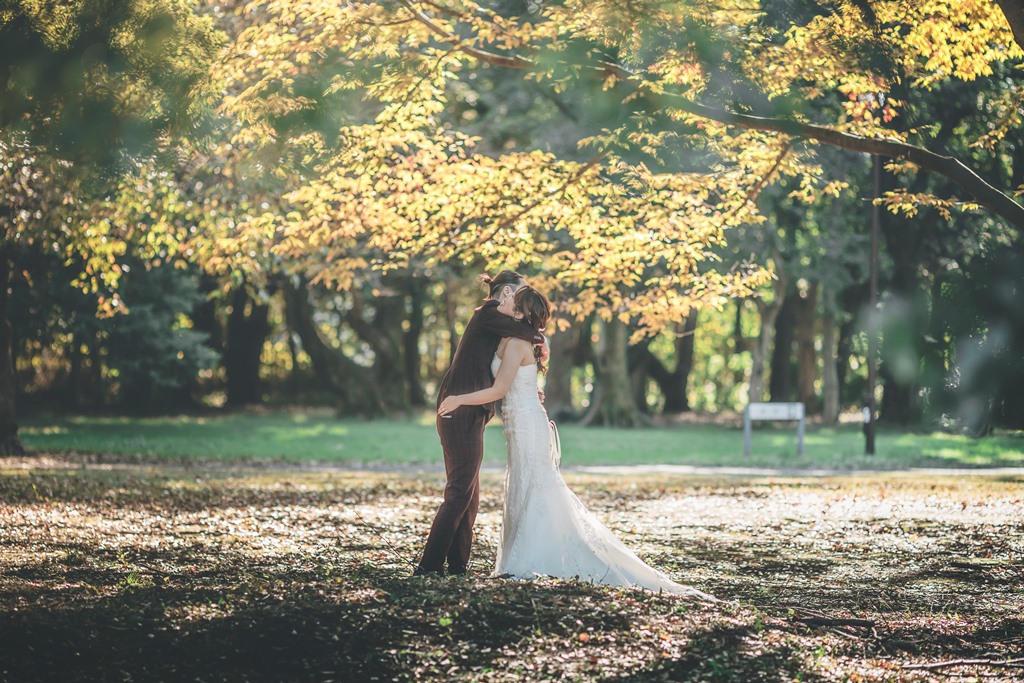 砧公園の紅葉シーズンにウェディングドレスを着て撮影した前撮り写真、赤や橙の紅葉と白いドレスのコントラスト
