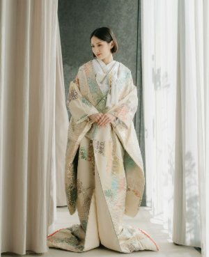 淡いクリーム地に草花をやわらかく描いた色打掛で正面に立つ、和装フォトウェディングの花嫁（衣装番号DMOS21）