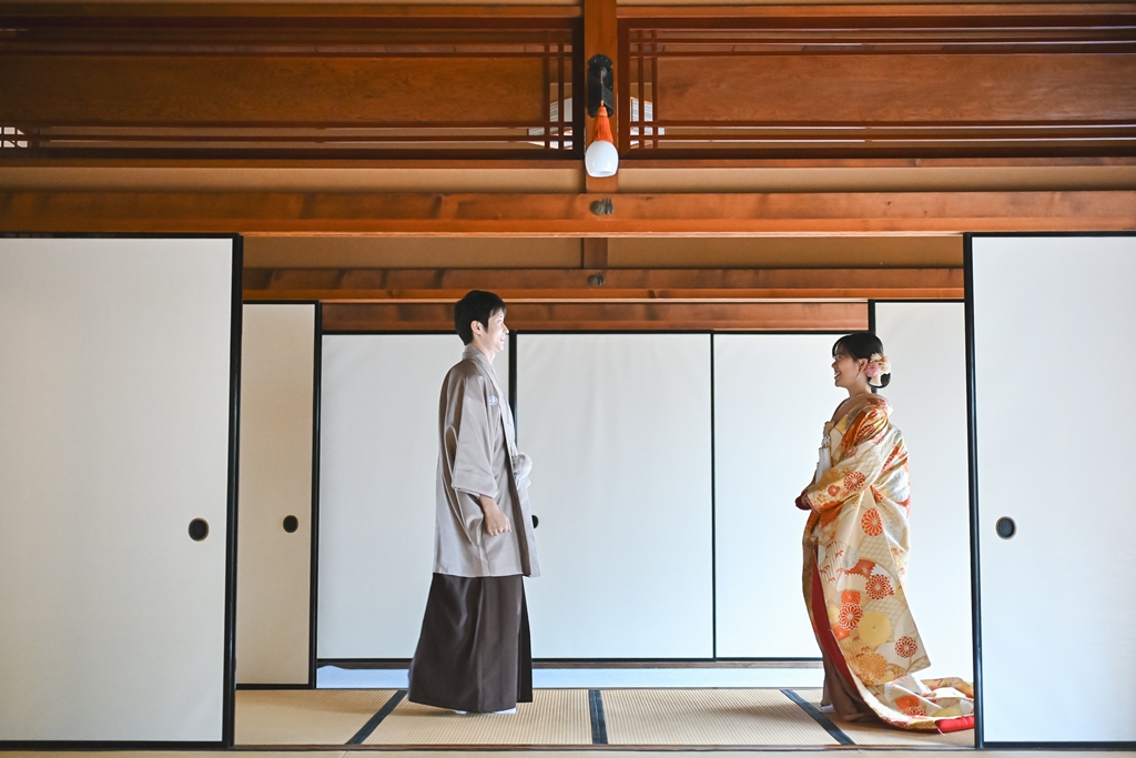 畳の和室で向き合う紋付袴の新郎と色打掛の花嫁。和装の前撮りとムービーを残すプラン
