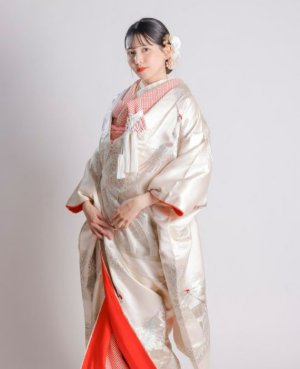鮮やかな赤いふきと優雅に舞う鶴を描いた白無垢で、縁起の良い和装の結婚写真に（衣装番号OB107）