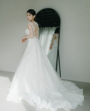 背中の大胆なカットが印象的なプロノビアスのウェディングドレスで、鏡の前で振り返る花嫁の後ろ姿を写した前撮り（衣装番号DC06）