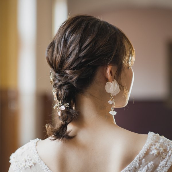 ゆるく巻いたハーフアップに編み込みと揺れるイヤリングを合わせたヘアアレンジ。レースのドレスで撮る洋装前撮り