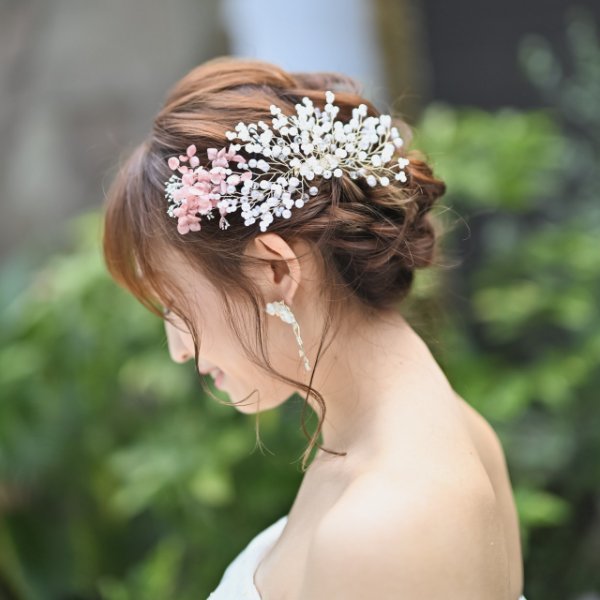 かすみ草とピンクの小花をたっぷり飾ったアップスタイル。ウェディングドレスに合わせるふんわりした前撮りのヘアアレンジ