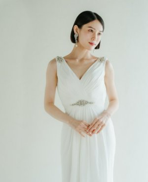 肩とウエストのビジューが輝くVネックのスレンダーラインドレスを着たプレ花嫁。White One（ホワイトワン）のウェディングドレス、表参道店（スレンダーライン／衣装番号DB04）